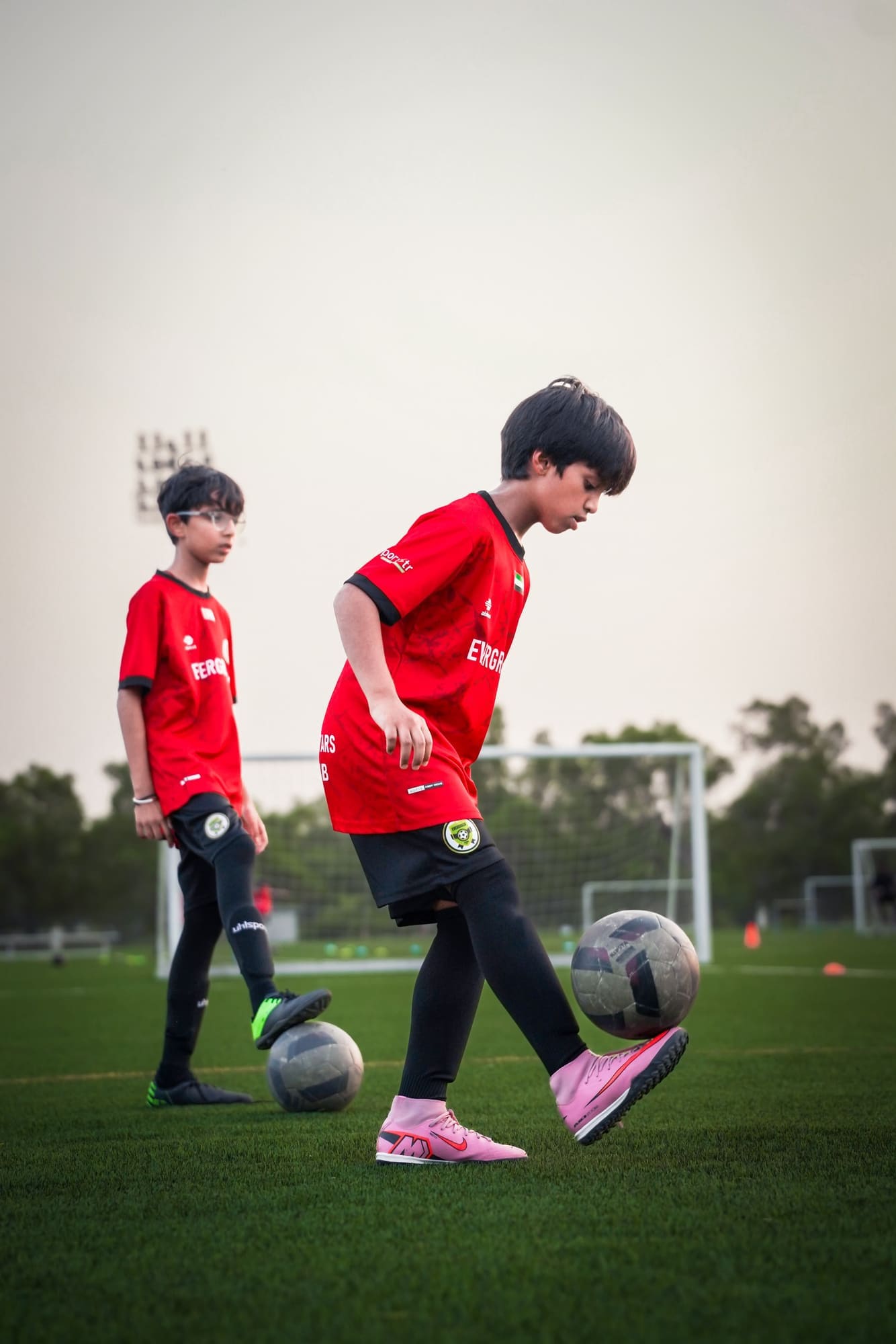 Two young players training with balls at their feet