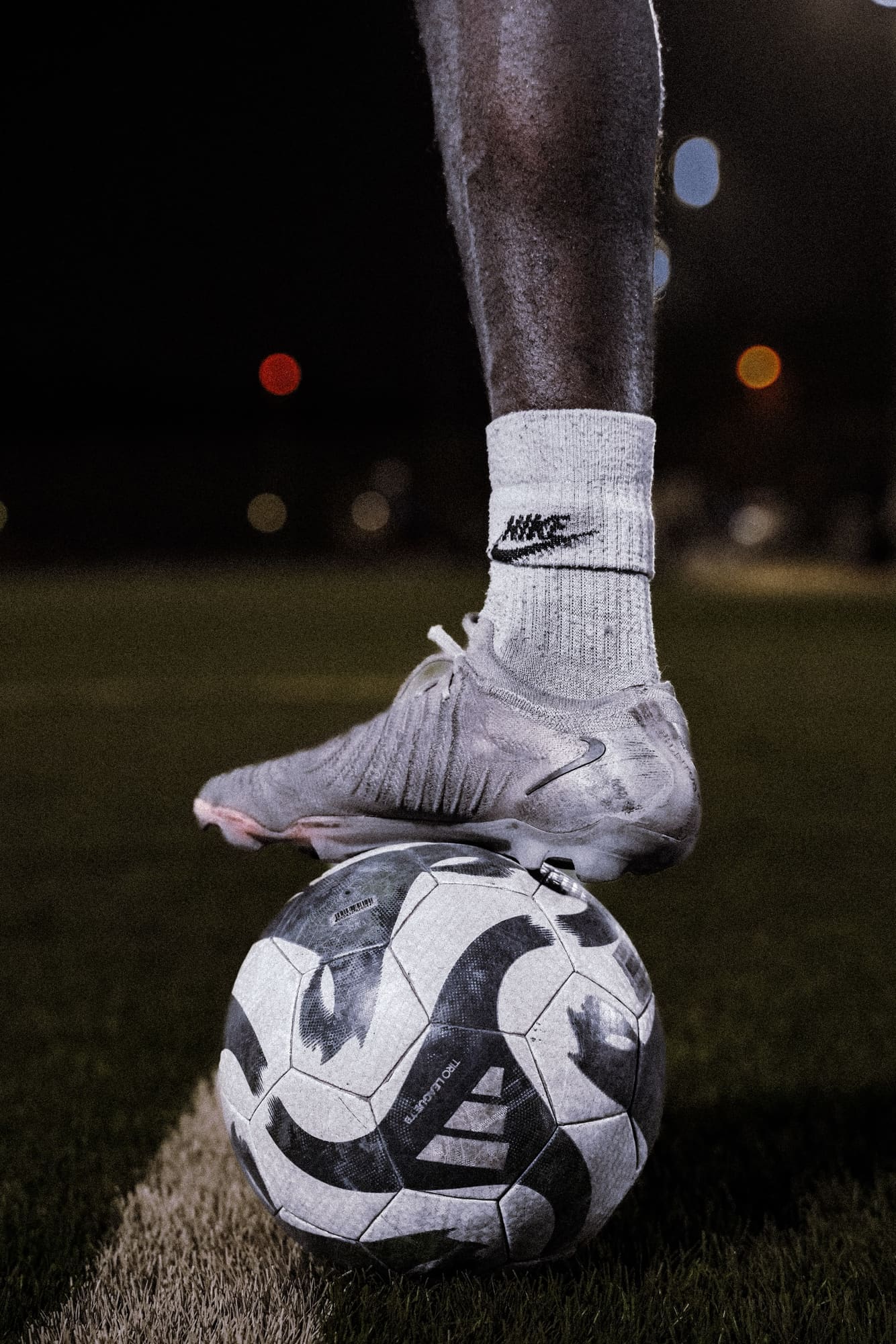 Close detail of a boot resting on a match ball