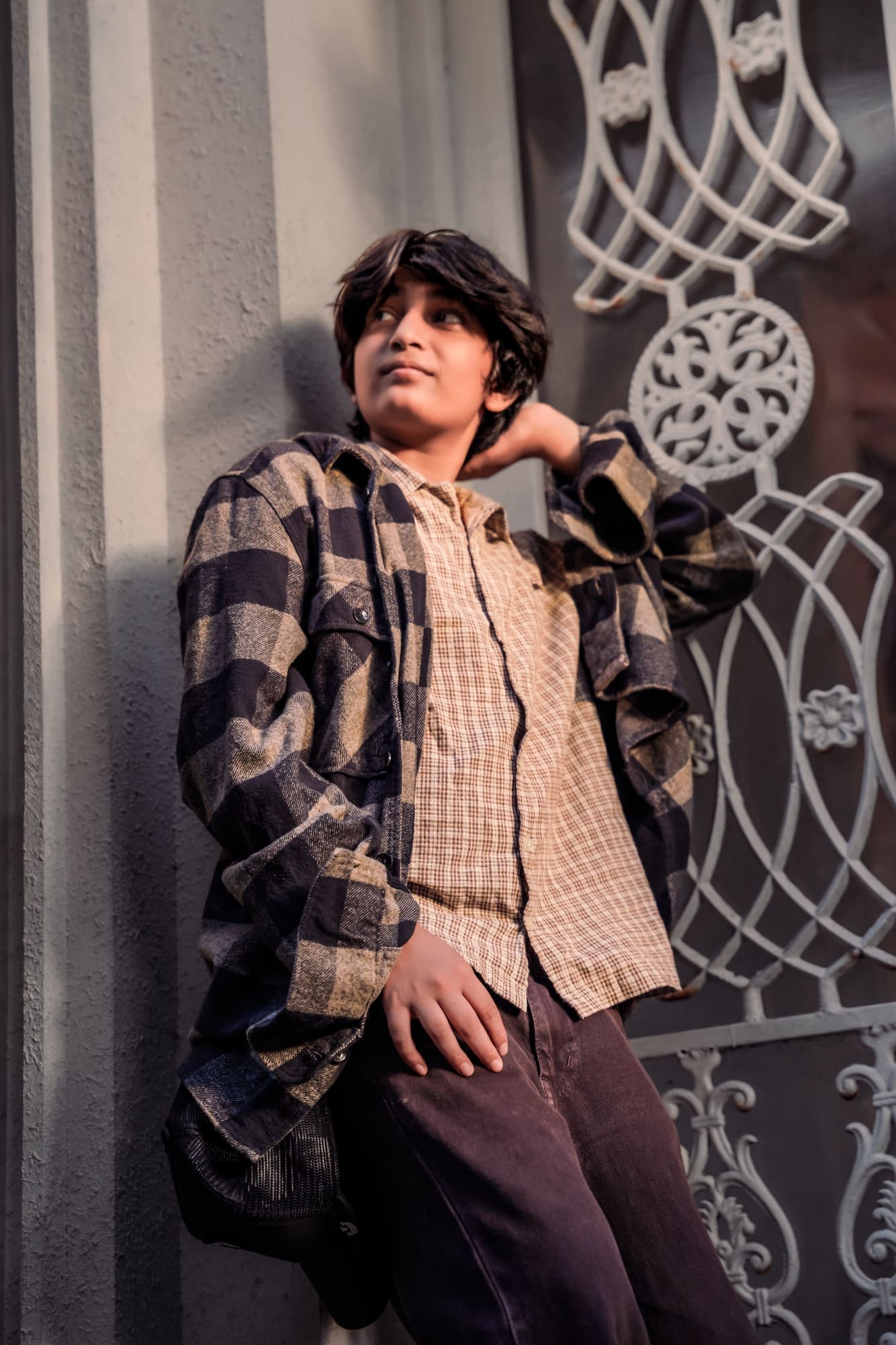 Environmental portrait against a textured wall at golden hour