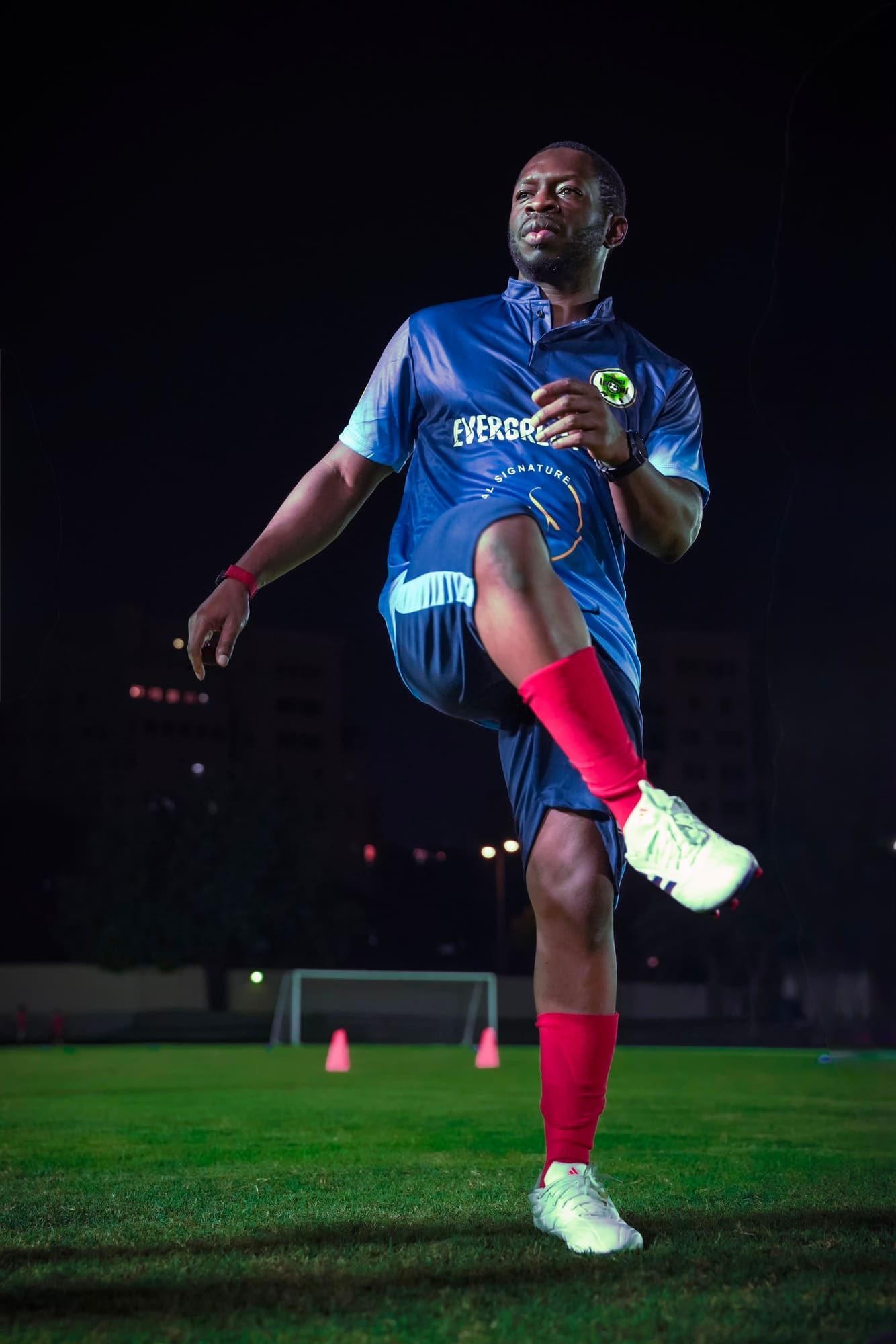 Player juggling a ball under floodlights