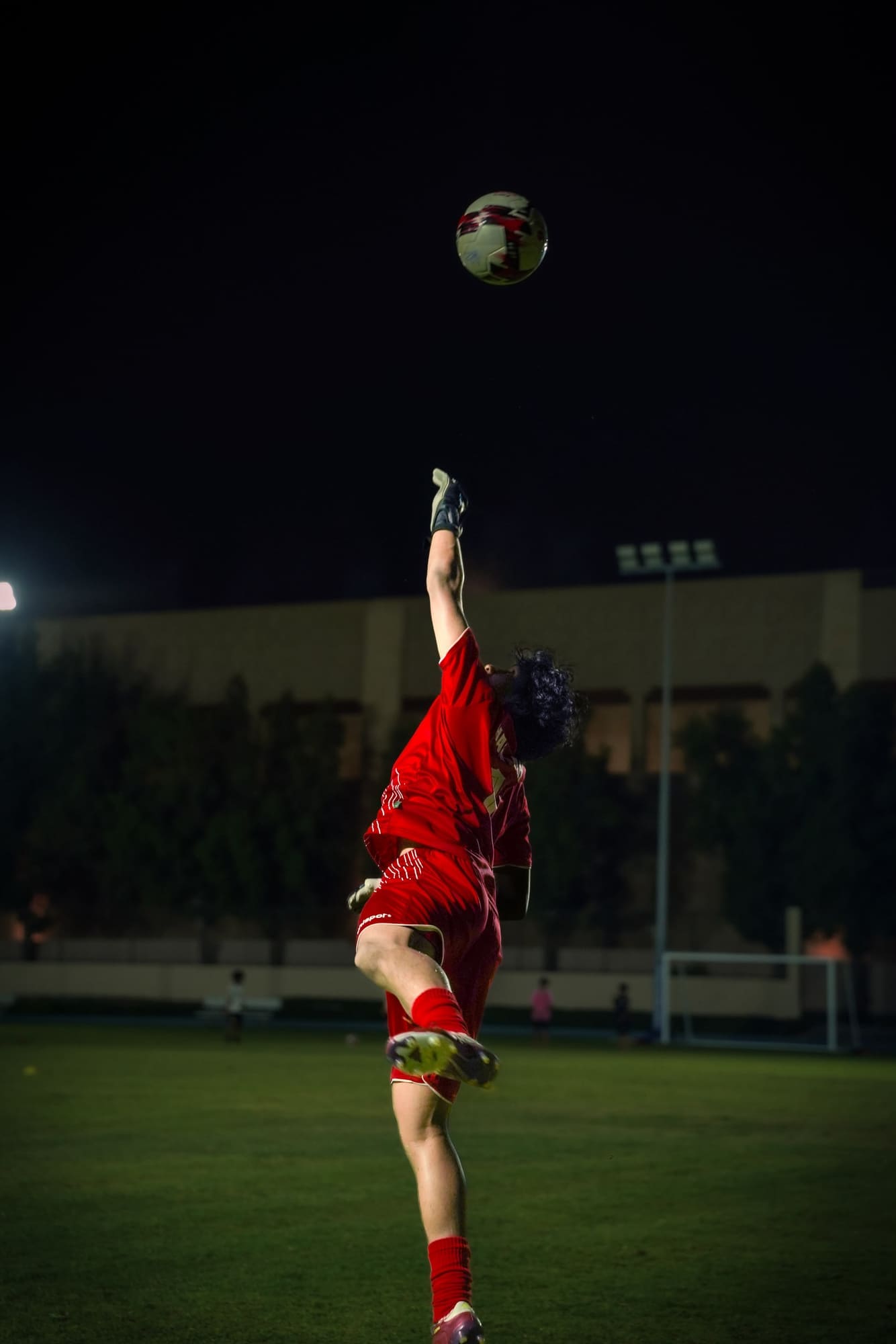 Player striking an overhead kick, ball suspended above