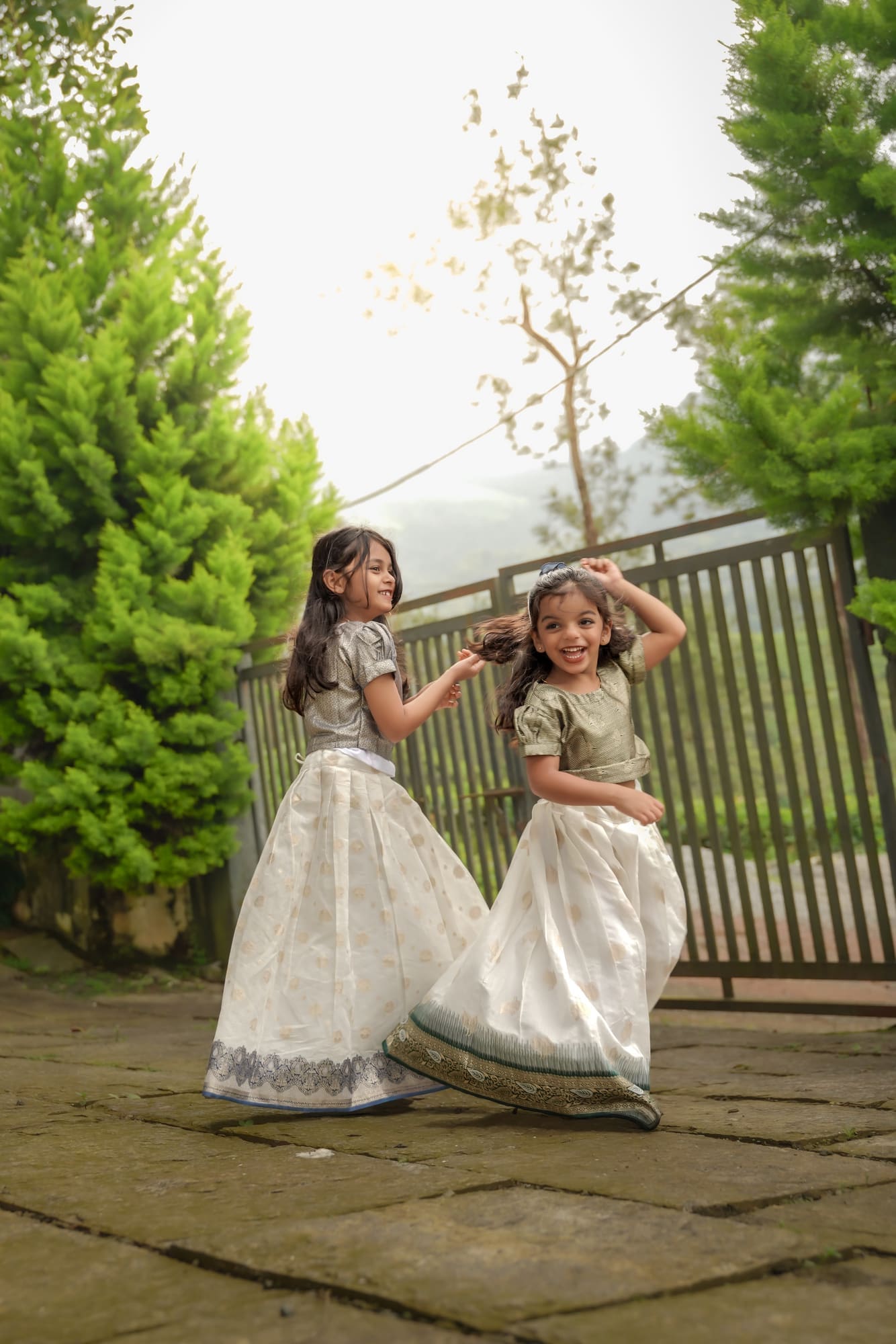 Two sisters walking through a garden in traditional dress