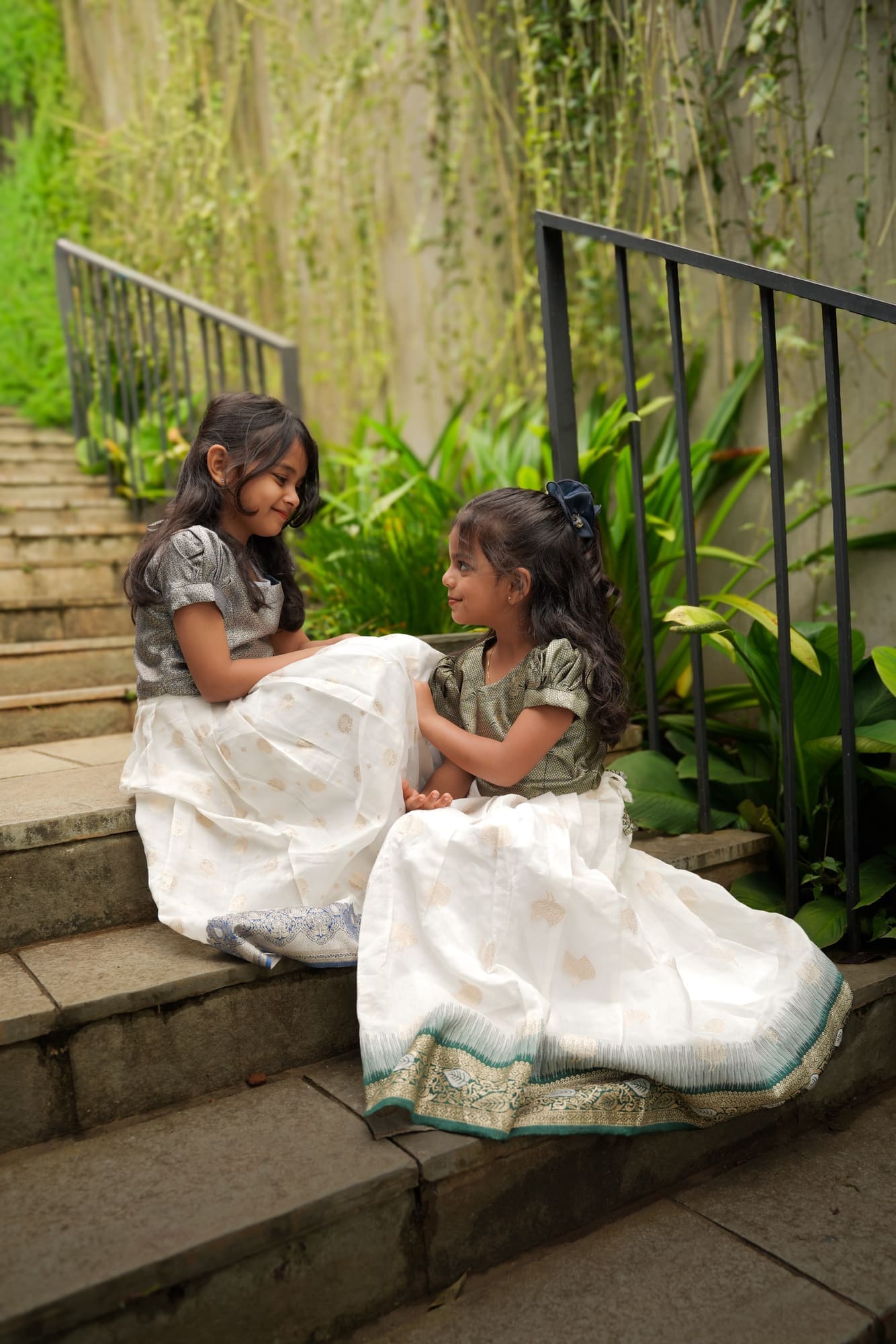 Two sisters seated together on stone steps